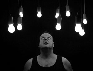 man looking up at illuminated light bulbs Your energy meter